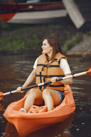 Woman paddling on a lake in a kayakの写真素材