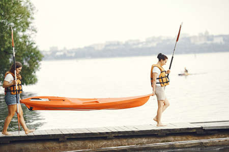 Women prepare to paddling on a lake in a kayakの写真素材