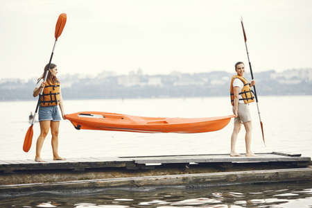 Women prepare to paddling on a lake in a kayakの写真素材