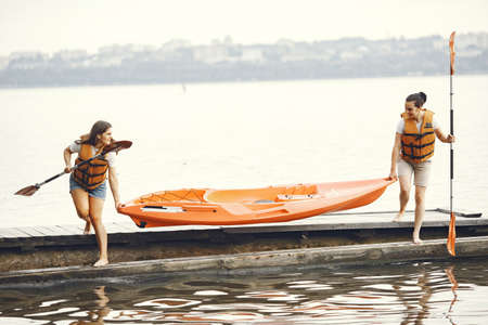 Women prepare to paddling on a lake in a kayakの写真素材