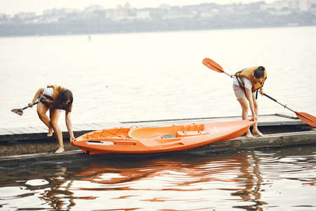 Women prepare to paddling on a lake in a kayakの写真素材