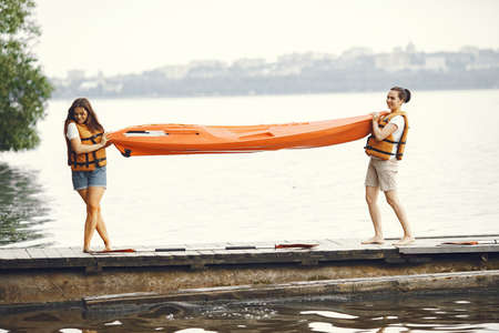 Women prepare to paddling on a lake in a kayakの写真素材