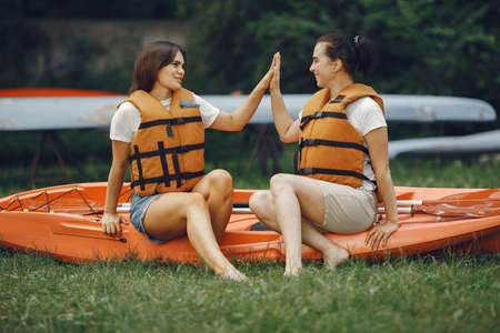 Women prepare to paddling on a lake in a kayakの写真素材