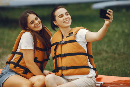 Women prepare to paddling on a lake in a kayakの写真素材