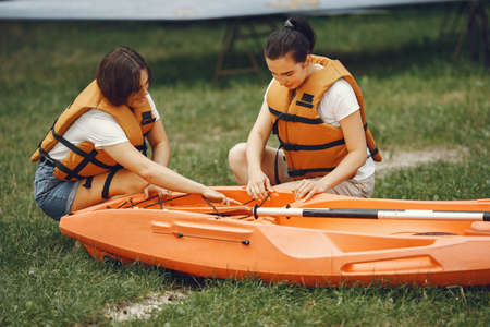 Women prepare to paddling on a lake in a kayakの写真素材