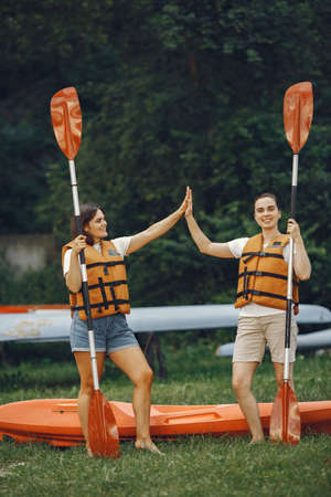 Women prepare to paddling on a lake in a kayakの写真素材