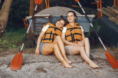 Women prepare to paddling on a lake in a kayakの写真素材