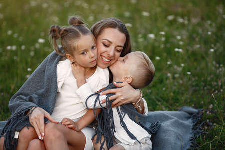 Mother with son and daughter resting in the park.の写真素材