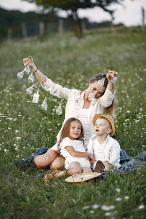 Mother with son and daughter resting in the park.の写真素材