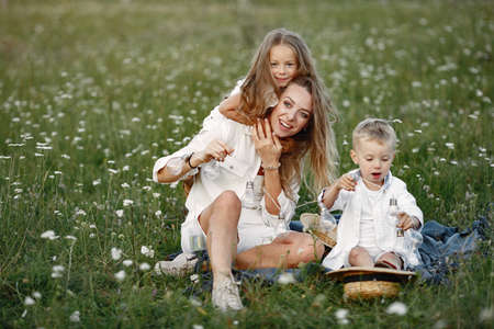 Mother with son and daughter resting in the park.の写真素材