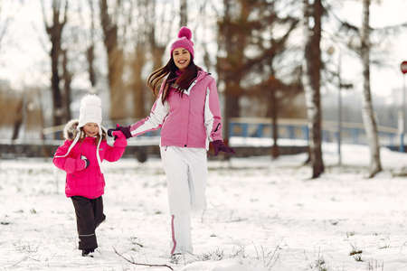Mother and child in winter clothes play in winter parkの写真素材