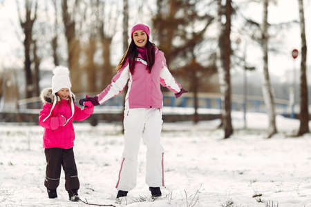 Mother and child in winter clothes play in winter parkの写真素材