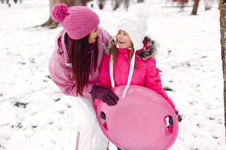 Mother and child in winter clothes play in winter parkの写真素材