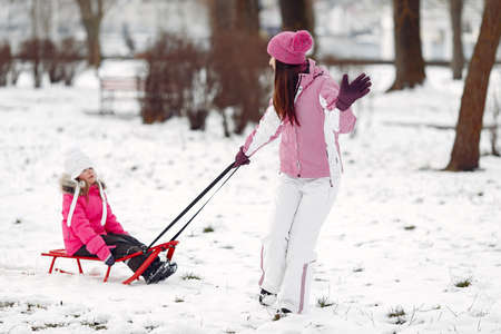 Mother and child in winter clothes play in winter parkの写真素材