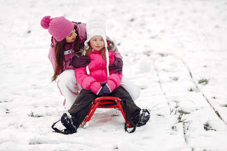 Mother and child in winter clothes play in winter parkの写真素材