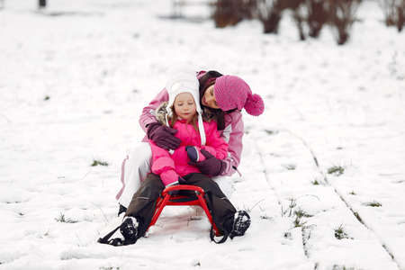 Mother and child in winter clothes play in winter parkの写真素材