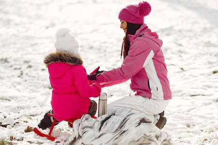 Mother and child in winter clothes play in winter parkの写真素材
