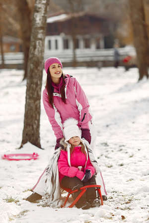 Mother and child in winter clothes play in winter parkの写真素材