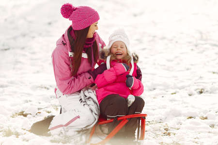 Mother and child in winter clothes play in winter parkの写真素材
