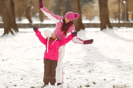 Mother and child in winter clothes play in winter parkの写真素材