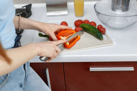 Beautiful girl in a kitchen with a vegetablesの写真素材