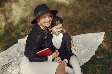 Elegant mother with daughter in a summer forest