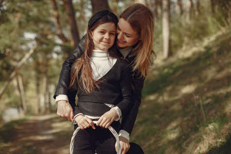 Elegant mother with daughter in a summer forestの写真素材