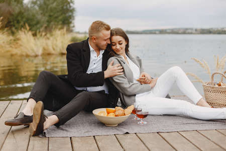 People sitting by the water with picnic setの写真素材
