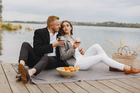 People sitting by the water with picnic setの写真素材