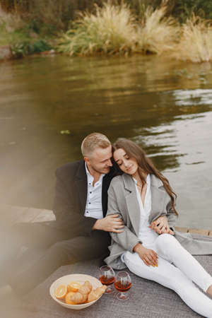 People sitting by the water with picnic setの写真素材