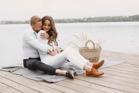 People sitting by the water with picnic setの写真素材