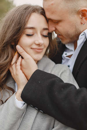 Cute couple in a park. Lady in a gray coat. People on the pier.の写真素材