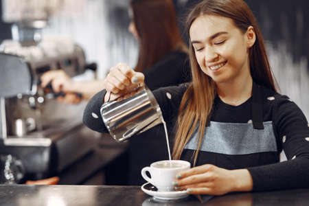 Young barista girl makes coffee and smilesの写真素材