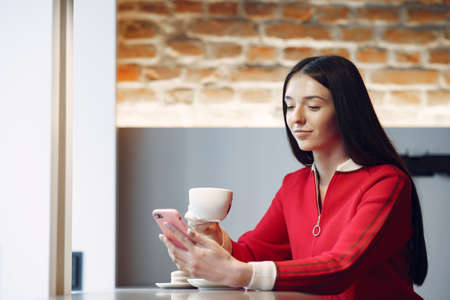 Woman drinking coffee in the morning at restaurantの写真素材
