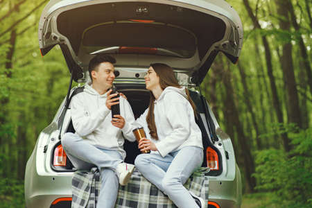 Couple in a forest sitting in a trunkの写真素材