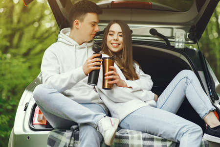 Couple in a forest sitting in a trunkの写真素材