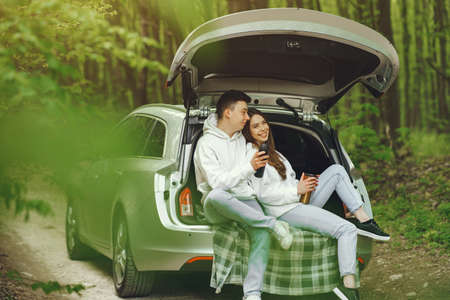 Couple in a forest sitting in a trunkの写真素材