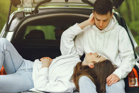 Couple in a forest sitting in a trunkの写真素材