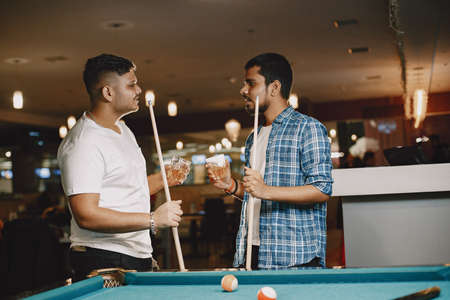 Men playing billiards in a clubの写真素材