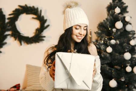 Beautiful girl at home near christmas treeの写真素材