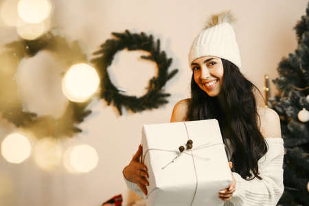 Beautiful girl at home near christmas treeの写真素材