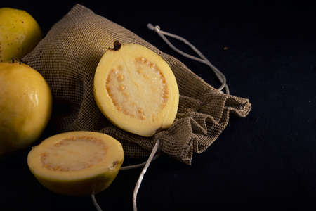 Yellow guava on black background, still life style. Healthy dietの写真素材