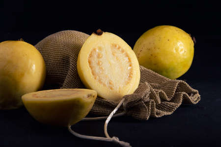 Yellow guava on black background, still life style. Healthy dietの写真素材