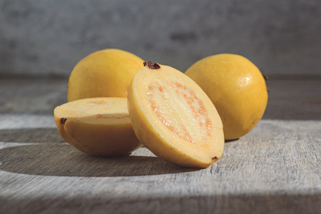 Yellow guava on wooden background. Vitamin C, healthy fruit diet.の写真素材