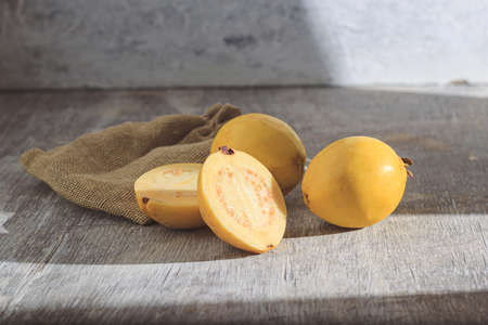 Yellow guava on wooden background. Vitamin C, healthy fruit diet.の写真素材