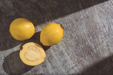 Yellow guava on wooden background. Vitamin C, healthy fruit diet.の写真素材