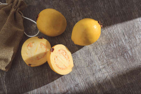 Yellow guava on wooden background. Vitamin C, healthy fruit diet.の写真素材