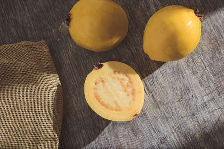 Yellow guava on wooden background. Vitamin C, healthy fruit diet.の写真素材