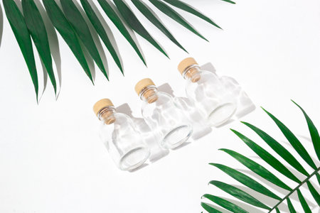 Three glass bottles with cork stoppers for perfumes with exotic plants. Mockup.の写真素材