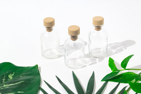 Three glass bottles with cork stoppers for perfumes with exotic plants. Mockup.の写真素材